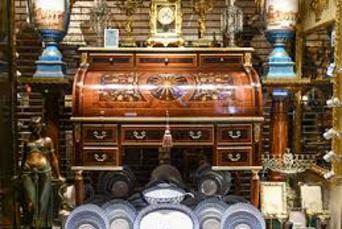 A large wooden desk with many drawers and clocks.