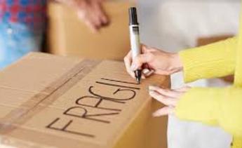 A person writing on the side of a box.