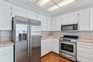 A beautiful kitchen with white cabinets and fridge