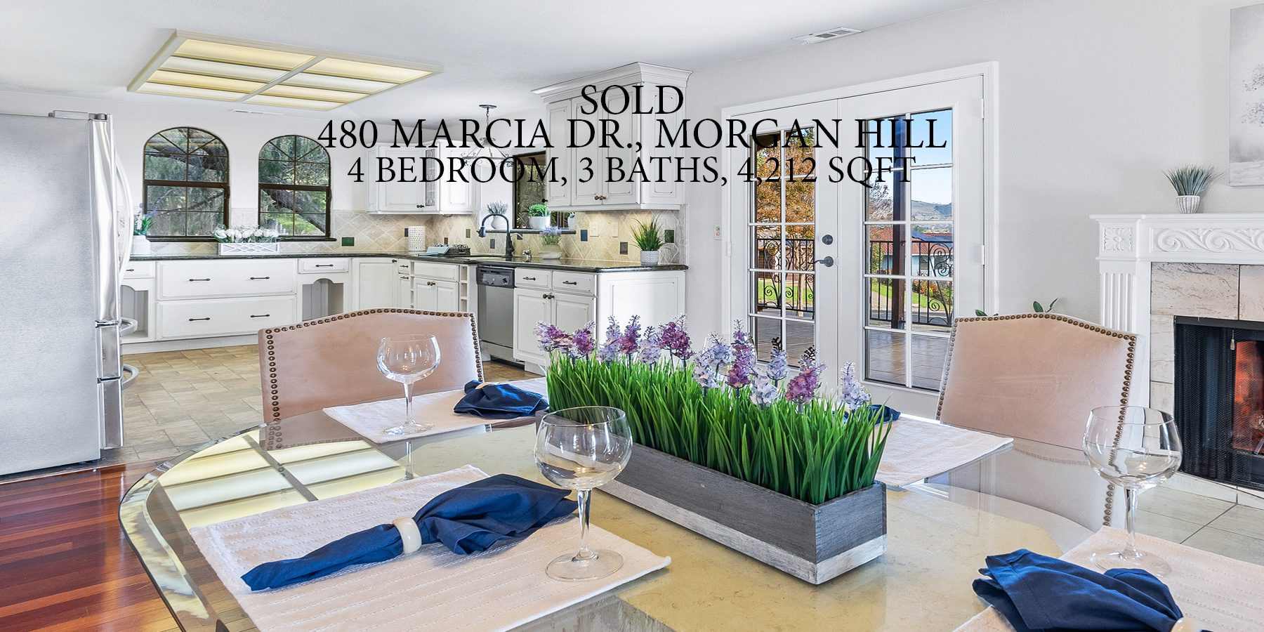 A kitchen with a table and chairs, and a bunch of plants in the middle.