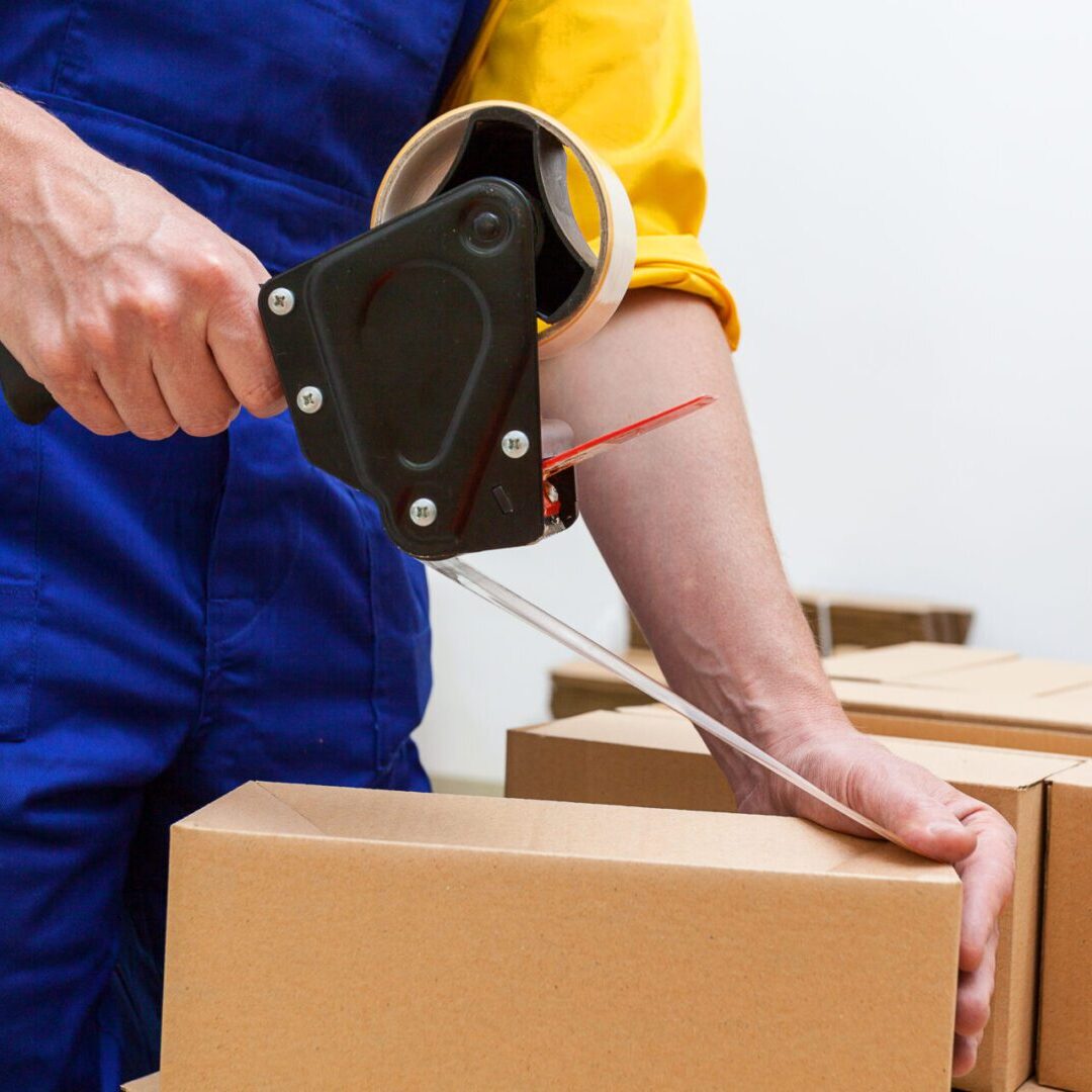 Closeup of a worker hands packing a box