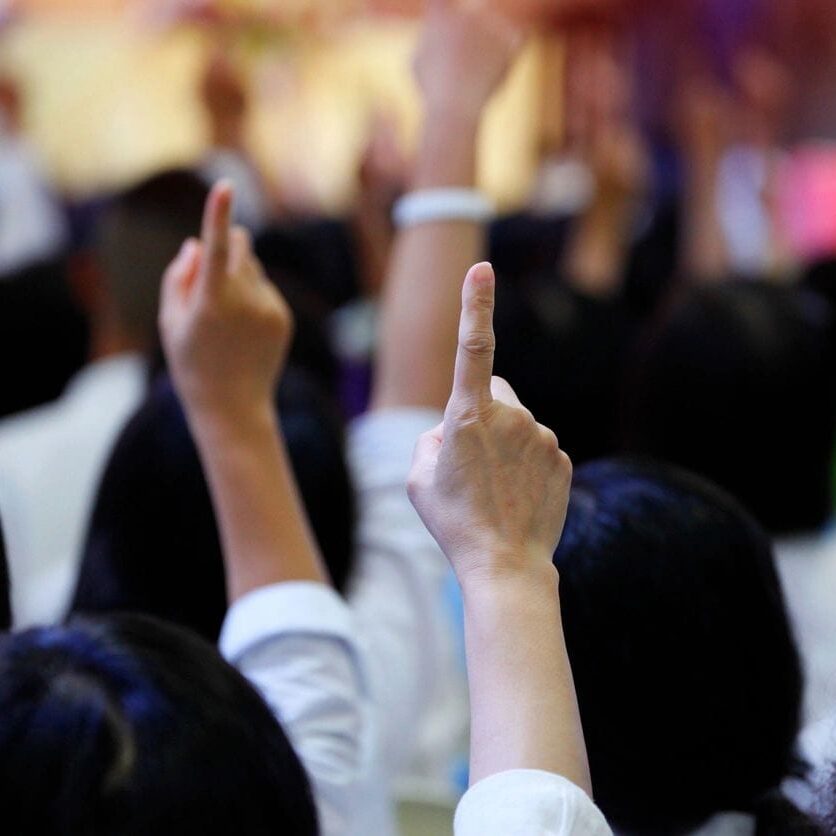 A group of people raising their hands in the air. A group of people raising their hands in the air.